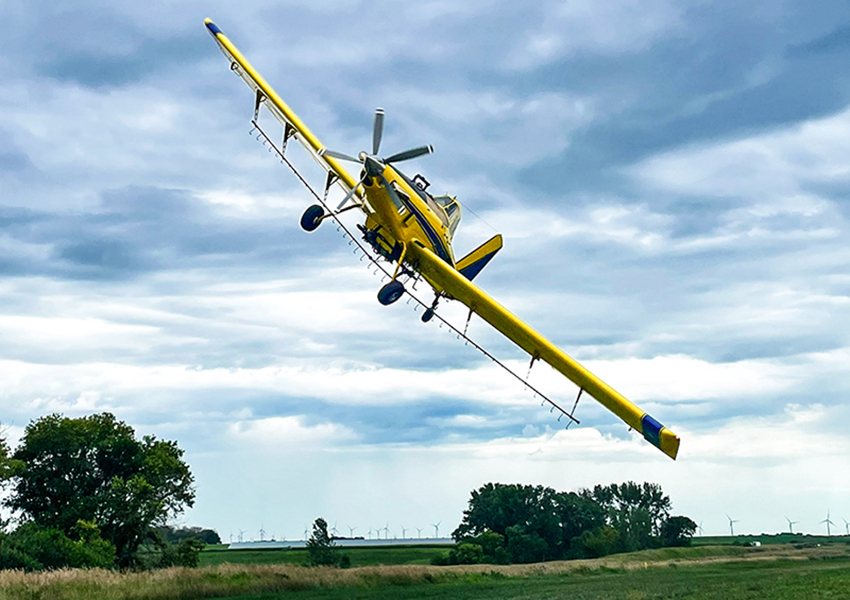 Crop duster plane flying over Iowa farmground
