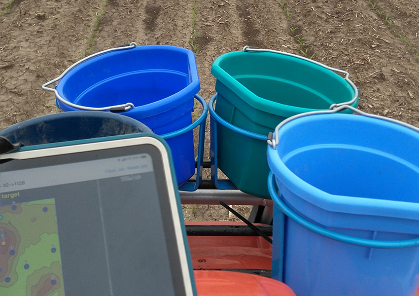 buckets and ipad on four-wheeler sampling a crop field